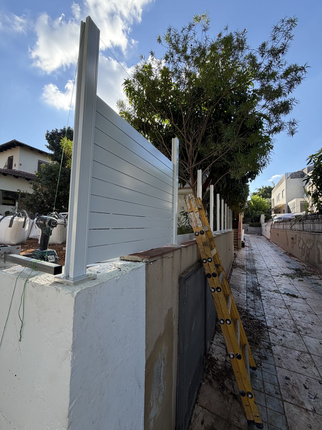 גדר מקטעים קצרים עם עמוד בכל מפרק עוקבת אחרי עיקול המגרש